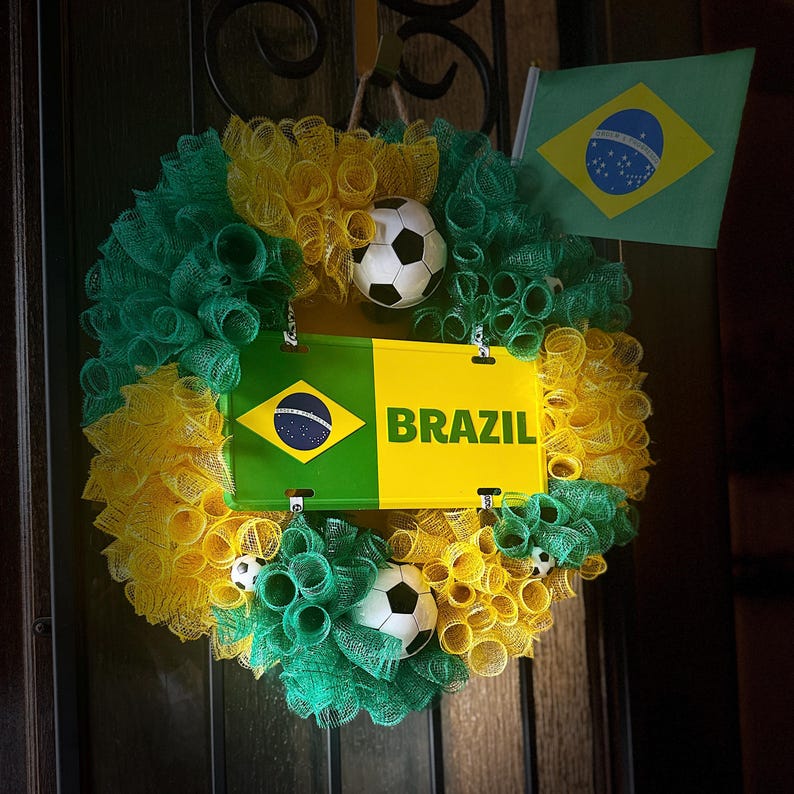 Puede incluir: Una corona decorativa con los colores de la bandera brasile&ntilde;a, con malla verde y amarilla, balones de f&uacute;tbol y un letrero que dice "BRAZIL". Tambi&eacute;n se incluye una peque&ntilde;a bandera brasile&ntilde;a.