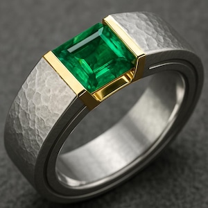Puede incluir: Anillo plateado con textura martillada y una gema verde rectangular con talla esmeralda. La gema está engastada en un bisel dorado. El anillo tiene un diseño moderno y minimalista.
