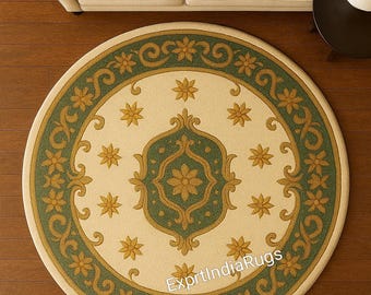 May include: Round area rug with a cream-colored center and a green and gold border. The rug features a central floral design and repeating star and scroll patterns. The text "ExprtIndiaRugs" is visible on the rug.
