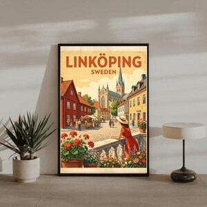 May include: Framed art print featuring a vintage travel poster for Linköping, Sweden. The artwork depicts a woman in a red dress overlooking a town square with a church in the background. The poster has a warm color palette with the text "LINKÖPING SWEDEN".
