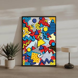 May include: A framed abstract art print featuring a vibrant 80s-inspired design. The artwork showcases a collage of geometric shapes, including triangles, zigzags, and circles, in bold primary colors like red, yellow, and blue, set against a black background.