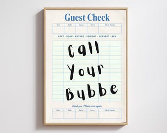 May include: A framed print featuring a vintage-style "Guest Check" design. The blue header reads "Guest Check," and the body includes the handwritten text "Call Your Bubbe." The print has a beige background and a wooden frame.