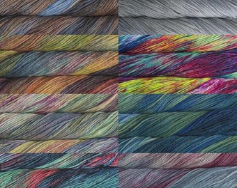 May include: A collection of colorful yarn skeins, each with a unique blend of hues. The yarns display a variety of colors, including blues, greens, yellows, oranges, and purples. The texture of the yarn is visible, suggesting a soft, textured material.