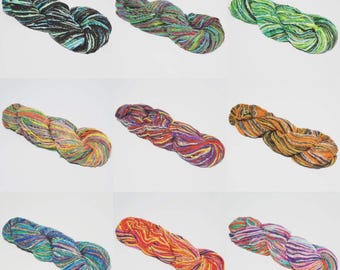 May include: Nine skeins of colorful yarn in various shades, including black, green, orange, and purple. The yarn is twisted into a braid-like shape, showcasing the different color combinations. Ideal for knitting and crochet projects.