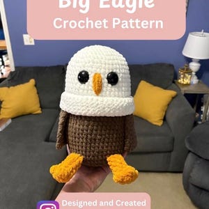 May include: A crocheted eagle plush toy featuring a white head, brown body, and bright orange feet and beak. The eagle has large black plastic safety eyes. Text on the image reads Big Eagle Crochet Pattern and Designed and Created By CrochetClareBear.