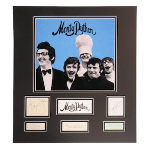 May include: A framed print featuring the comedy group Monty Python. The image includes a group photo with the text "Monty Python" above. Below the photo are six smaller images with signatures and the Monty Python logo.