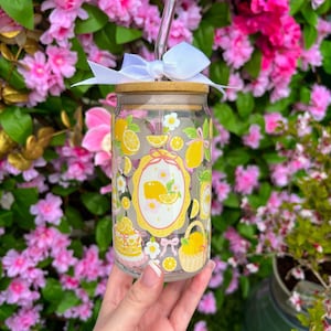 May include: A white ceramic mug with a black handle and the text "But First, Coffee" in a handwritten style. The mug is on a white surface. The mug is approximately 4 inches tall.
