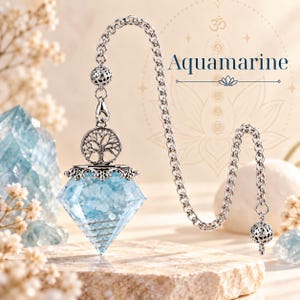 May include: A faceted light blue aquamarine crystal pendulum hanging from a silver-toned metal chain. The pendulum features a circular silver charm with a tree design and a small filigree bead. The text Aquamarine is visible.