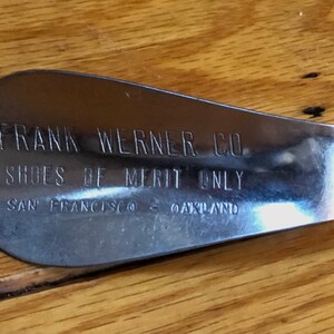 May include: A silver shoe stretcher with the text "FRANK WERNER CO. SHOES OF MERIT ONLY SAN FRANCISCO - OAKLAND" engraved on it.