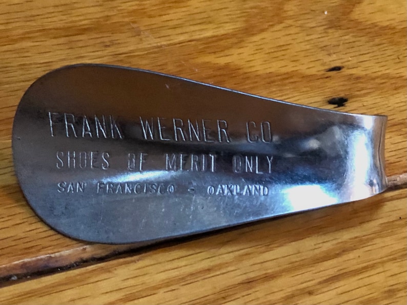May include: A silver shoe stretcher with the text "FRANK WERNER CO. SHOES OF MERIT ONLY SAN FRANCISCO - OAKLAND" engraved on it.