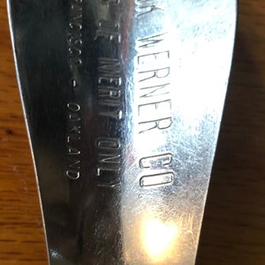 May include: A silver shoehorn with the text "FRANK WERNER CO. SALES OF MERIT ONLY. SILVERSC. - OAKLAND" engraved on the back.