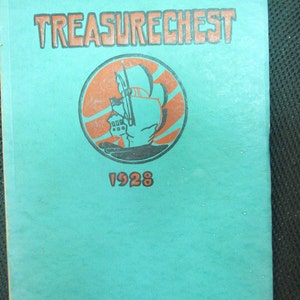 May include: A teal blue yearbook with the title "TREASURECHEST" in orange lettering. A circular emblem features a black silhouette of a ship with orange sails and waves. The year "1928" is printed below the emblem.