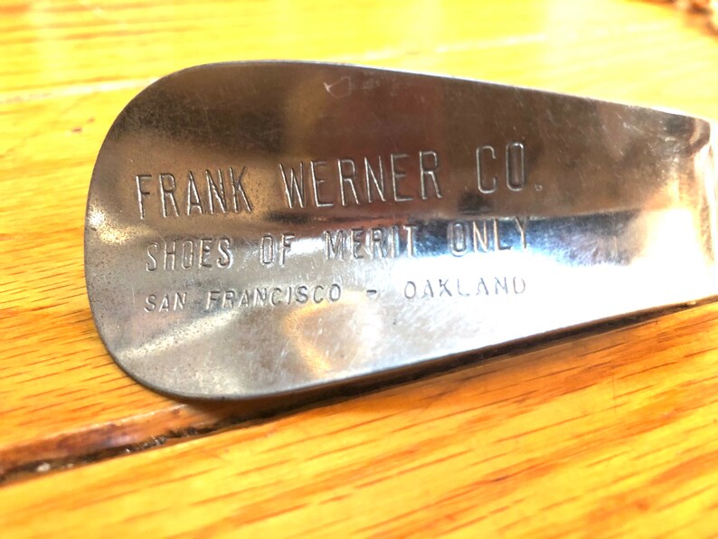 May include: A silver shoe stretcher with the text "FRANK WERNER CO. SHOES OF MERIT ONLY SAN FRANCISCO - OAKLAND" engraved on it.