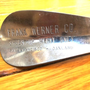 May include: A silver shoe stretcher with the text "FRANK WERNER CO. SHOES OF MERIT ONLY SAN FRANCISCO - OAKLAND" engraved on it.