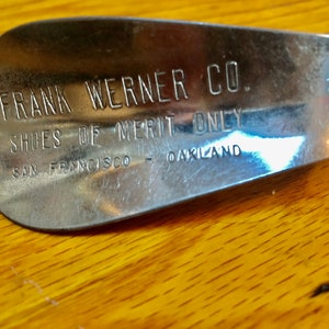 May include: A silver shoehorn with the text "FRANK WERNER CO. SHOES OF MERIT ONLY SAN FRANCISCO - OAKLAND" engraved on it.