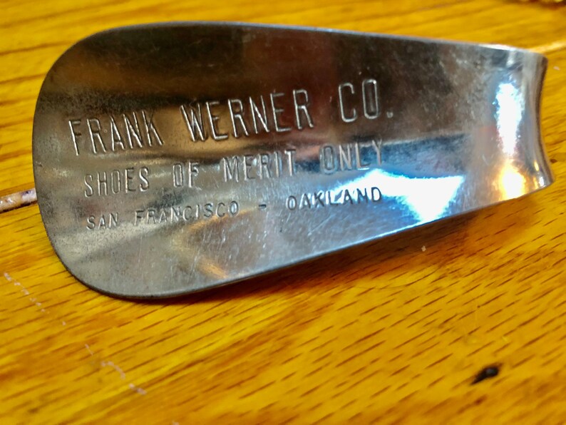 May include: A silver shoehorn with the text "FRANK WERNER CO. SHOES OF MERIT ONLY SAN FRANCISCO - OAKLAND" engraved on it.
