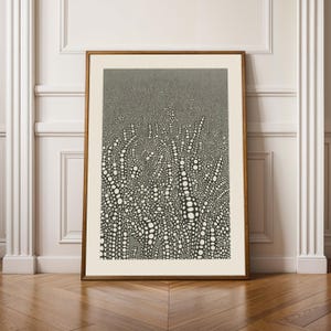 May include: Abstract black and white art print in a wooden frame. The artwork features a pattern of organic shapes and dotted textures, creating a visually dynamic composition. The print is displayed against a neutral background, enhancing its modern aesthetic.
