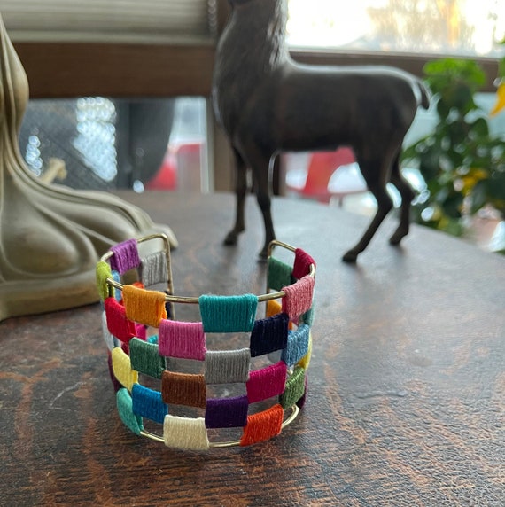 Vintage gold and multi-colored thread cuff bracelet.