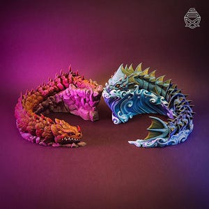 May include: Two sculpted dragon figures facing each other. The left dragon is orange and red with a rocky texture. The right dragon is blue and green, emerging from sculpted waves with a finned tail. Both figures feature sharp scales and horns.