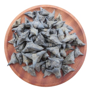 May include: A wooden plate filled with a pile of gray, spiky water caltrops. The caltrops have a unique, star-like shape with sharp points. The plate is round and made of a reddish-brown wood, set against a white background.