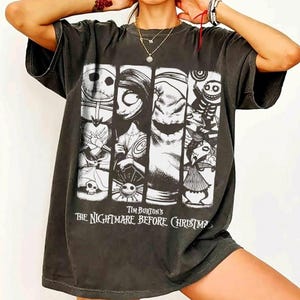 Peut inclure: Un t-shirt gris anthracite &agrave; manches courtes avec une impression graphique en noir et blanc repr&eacute;sentant des personnages de Tim Burton's The Nightmare Before Christmas. Le motif se compose de quatre panneaux verticaux avec des figures.