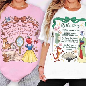 May include: Two t-shirts, one pink and one white, each with a colorful graphic design. The pink shirt features a fairytale theme with text, a deer, and an apple. The white shirt has a quote and illustrations.