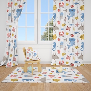 May include: A white rug, curtains, and a cushion featuring a colourful sea life pattern. The design includes crabs, fish, seahorses, and jellyfish in red, blue, yellow, and grey. A small wooden chair sits on the rug.