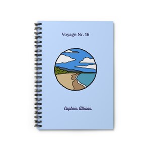 Può includere: Quaderno a spirale con copertina azzurra. La copertina presenta il testo "Voyage Nr. 16" e "Captain Allison". Un'illustrazione circolare raffigura una scena di spiaggia con acqua blu, sabbia e nuvole.