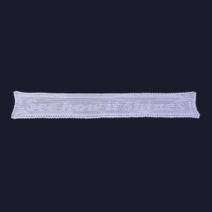 Puede incluir: Un tapete rectangular blanco de ganchillo con un diseño calado detallado. Los bordes son festoneados y el patrón presenta formas geométricas repetidas. El tapete se muestra sobre un fondo oscuro, resaltando su intrincada textura.