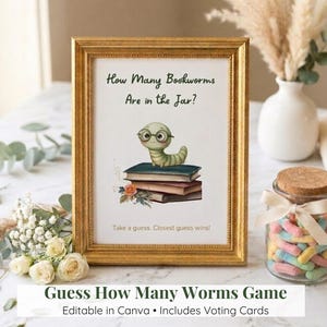 May include: A framed sign with gold trim features the text "How Many Bookworms Are in the Jar?" above an illustration of a cartoon worm wearing glasses on a stack of books. The sign is for a guessing game. A jar of colorful candies is in the background.