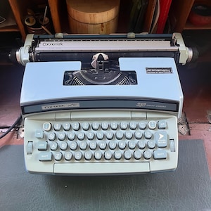 Máquina de escribir eléctrica Smith-Corona Coronamatic Coronet Super 12 con estuche, color azul claro bicolor.