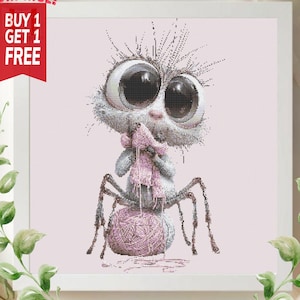 May include: A whimsical cross-stitch design featuring a cartoonish creature with large eyes, a pink scarf, and a ball of yarn. The creature has spider-like legs and is set against a light pink background. The text "SURPRISE! BUY 1 GET 1 FREE" is in the upper left corner.