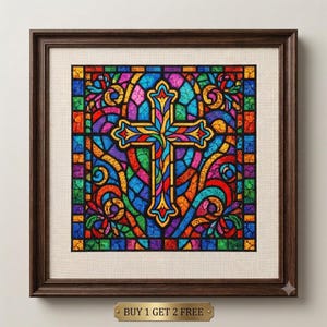 May include: A square framed cross-stitch artwork featuring a vibrant stained glass pattern with a central cross. The design uses a palette of blue, red, green, yellow, and purple threads on a cream fabric, enclosed in a dark brown wooden frame.