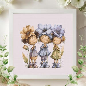 May include: A framed cross-stitch artwork featuring three stylized figures with large flower hats. The figures are dressed in pastel-colored dresses and boots, holding stems. The artwork is set against a light pink background, with floral accents.