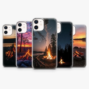 May include: A set of phone cases showcasing campfire scenes. Each case presents a unique outdoor vista with a blazing campfire, trees, and a colourful sky. The cases are designed to fit a smartphone.