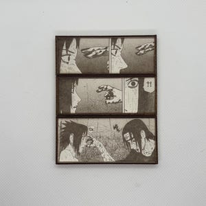 Peut inclure: Trois panneaux en bois avec des illustrations de manga en noir et blanc. Le panneau sup&eacute;rieur montre deux visages et une main. Le panneau du milieu montre un visage, une main et un visage surpris avec un point d'interrogation. Le panneau inf&eacute;rieur montre deux visages et le mot "TOK".