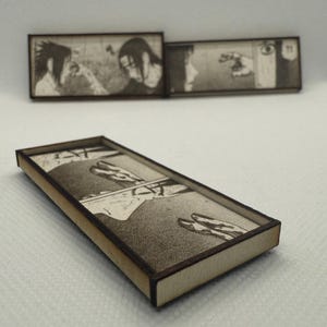Peut inclure: Pi&egrave;ces d&eacute;coratives rectangulaires en bois avec des illustrations de manga. Les pi&egrave;ces ont un cadre en bois clair et une image d&eacute;taill&eacute;e en noir et blanc. L'image repr&eacute;sente des sc&egrave;nes d'une s&eacute;rie de mangas, avec des personnages en action.