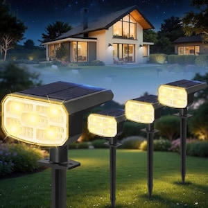 Puede incluir: Escena nocturna con una casa iluminada por focos solares. Los focos tienen un marco negro y una rejilla de luces amarillas brillantes. La casa tiene varias ventanas y está rodeada de un césped verde.