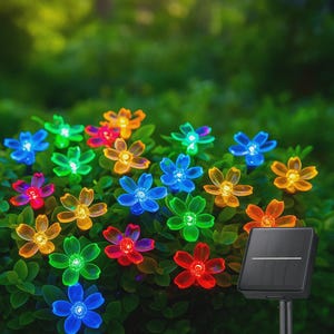 May include: A collection of colorful solar-powered flower lights in a garden setting. The lights are in various colors, including blue, green, orange, and red. A black solar panel is visible in the image.