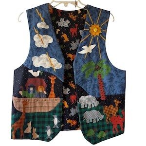 Può includere: Un gilet reversibile e colorato con un'illustrazione a tema biblico. Un lato presenta un cielo blu con nuvole, un sole e una palma. L'altro lato ha uno sfondo blu scuro con motivi di animali.