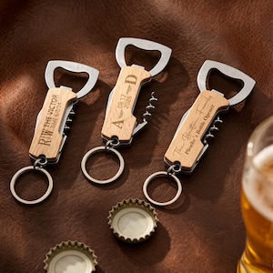 May include: Three personalised bottle openers with keyrings. Each opener has a wooden handle with a stainless steel bottle opener, corkscrew, and a small knife. The handles are engraved with names and dates. Two bottle caps are visible.