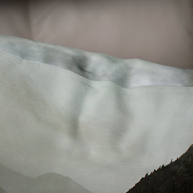 May include: A light green and gray fabric with a subtle texture. The fabric has a mountain scene printed on it.