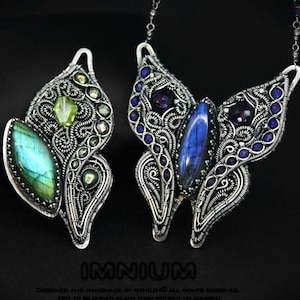 Peut inclure: Deux pendentifs artisanaux en fil d'argent avec des pierres précieuses. L'un est en forme de feuille avec une pierre verte et bleue. L'autre est en forme de papillon avec des pierres bleues et violettes. Les pendentifs sont présentés sur fond noir.