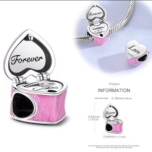 May include: A pink heart-shaped charm with the word "Forever" engraved on the lid and a ring inside. The charm is shown open and closed, and also next to a "Love" charm. The charm measures 0.62 inches (1.57 cm) high and 0.44 inches (1.11 cm) wide.