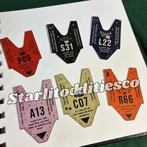 May include: Six V-shaped stickers with various colors and designs. The stickers feature text and icons including P09 in red, S31 in black, L22 in dark blue, A13 in light purple, C07 in light yellow, and R66 in orange. Each sticker displays unique labels.