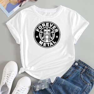 Puede incluir: Camiseta blanca con un diseño gráfico en blanco y negro. El diseño es una parodia de un logotipo conocido, con las palabras "FOREVER METAL" rodeando una imagen estilizada de una mujer. La camiseta se combina con vaqueros azules y zapatillas blancas.