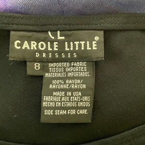 May include: A black tag with white text that reads "Carole Little Dresses" and "Imported Fabric, Tissus Importes, Materiales Importados." The tag also says "100% Rayon/Rayonne/Rayon", "Made in USA, Fabrique aux Etats-Unis, Hecho en Estados Unidos", and "Side Seam for Care."
