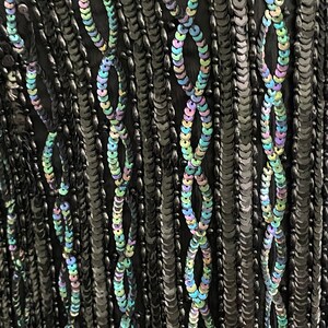 May include: Black fabric with iridescent sequins arranged in a vertical pattern. The sequins are arranged in a repeating pattern of ovals.
