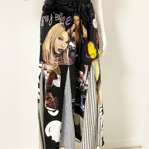 May include: A long black skirt with a patchwork design featuring images of celebrities and cartoon characters. The skirt has a drawstring waist and a flowing silhouette.
