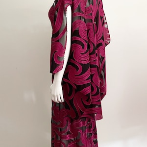 May include: A long, black and magenta dress with a swirling pattern. The dress is made of a sheer fabric with a velvet overlay.